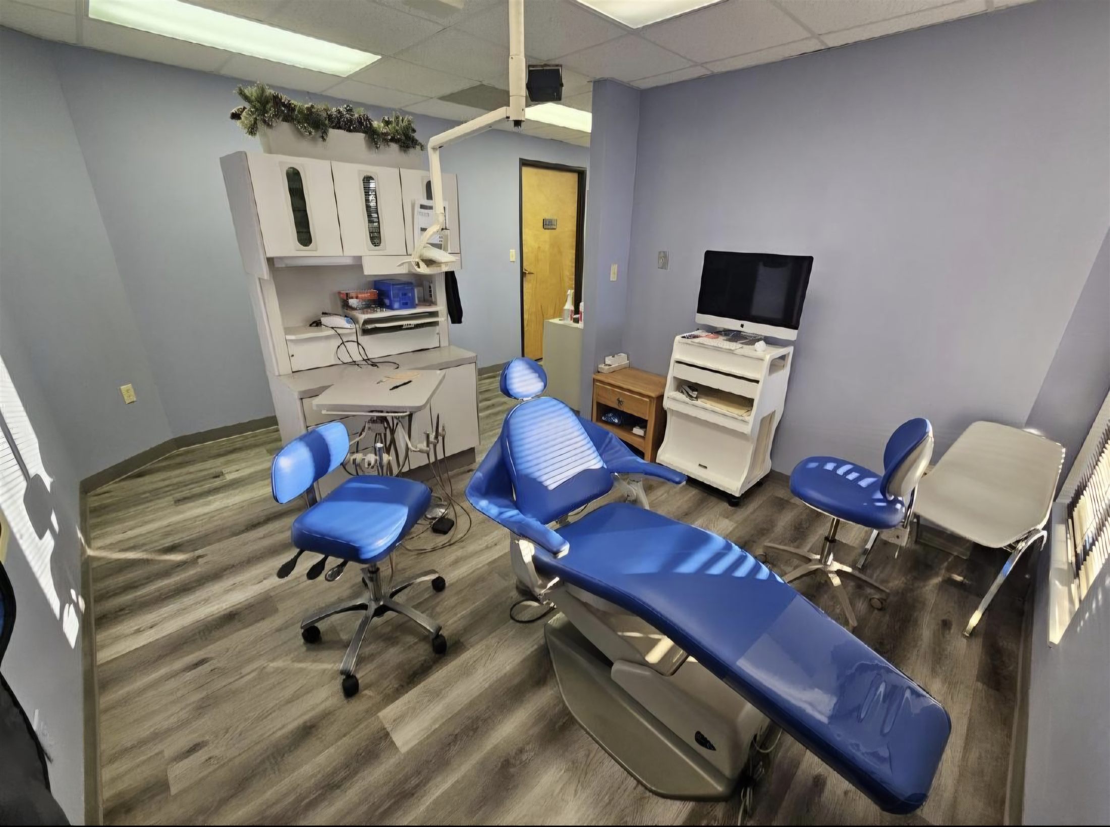Operatory before equipment removal: dental chair, delivery unit, stools, and monitor in place